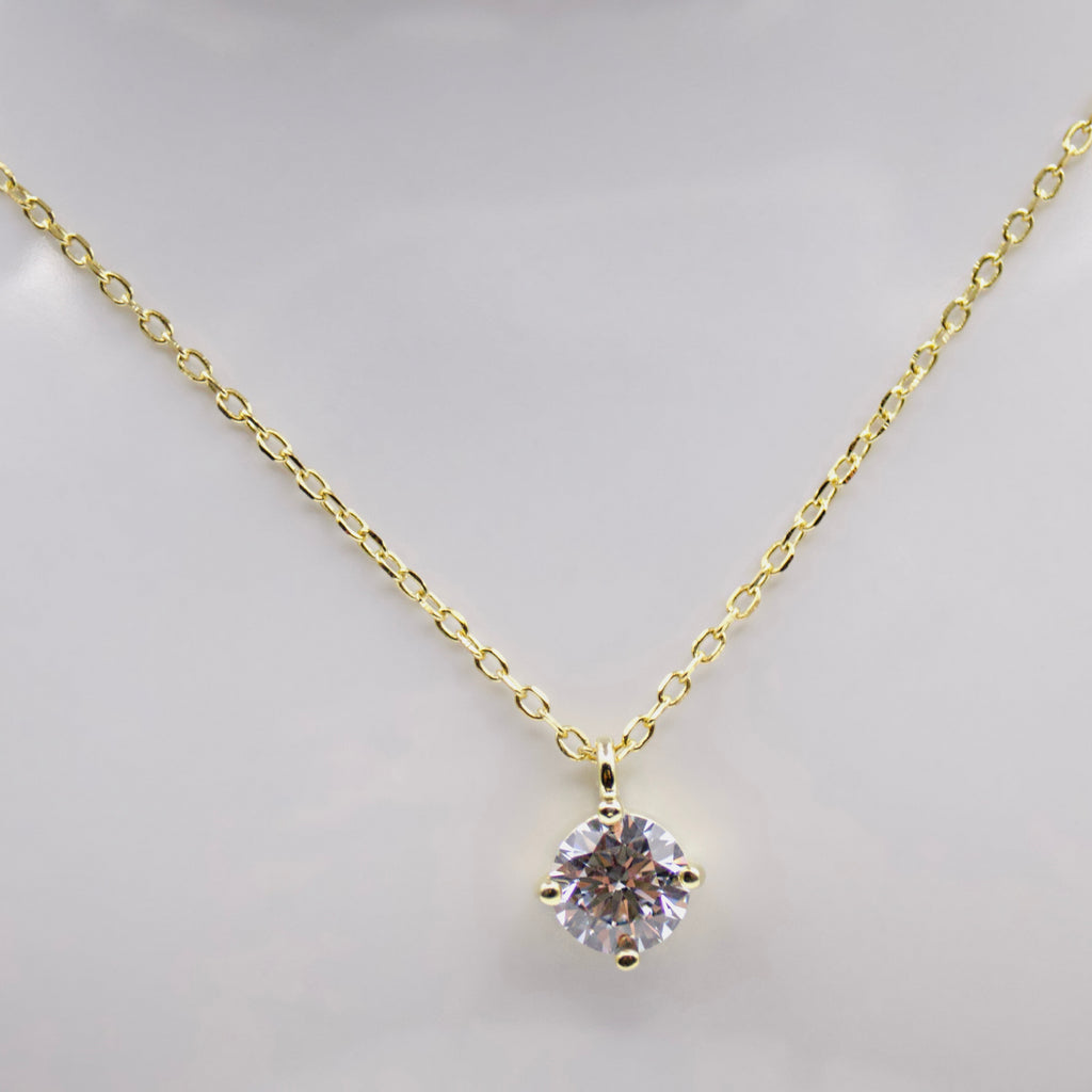 Gold plated silver necklace with a diamond zircon pendant on a light background