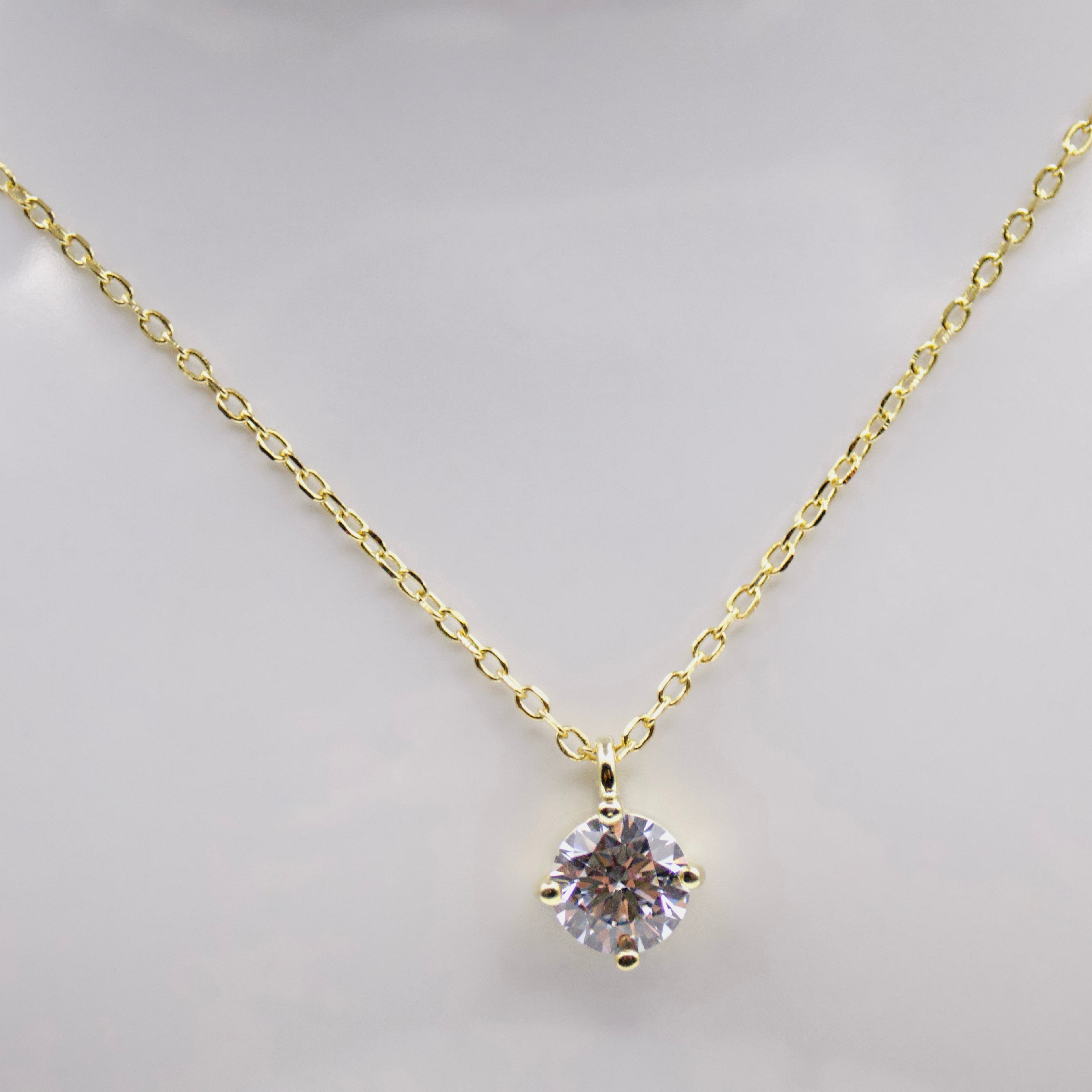 Gold plated silver necklace with a diamond zircon pendant on a light background